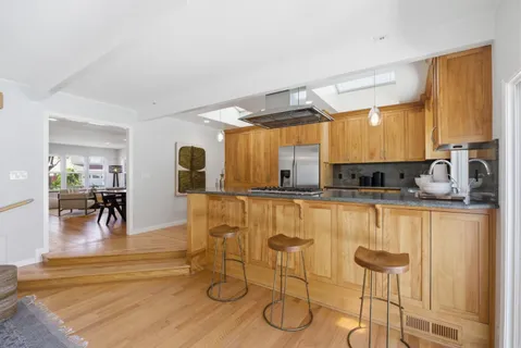 a kitchen with kitchen island granite countertop a sink appliances cabinets and a counter top space