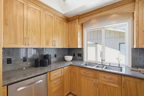 a kitchen with granite countertop a stove and a wooden floors