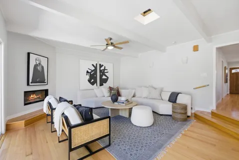 a living room with furniture two window and a flat screen tv