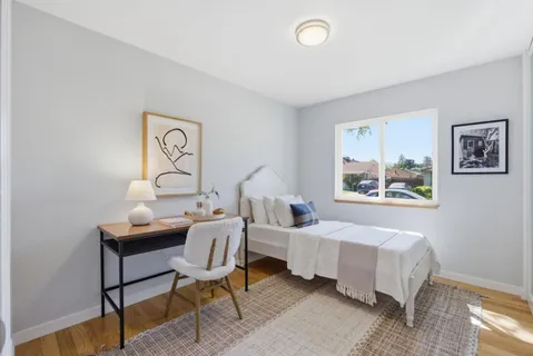 a bedroom with a bed and wooden floor