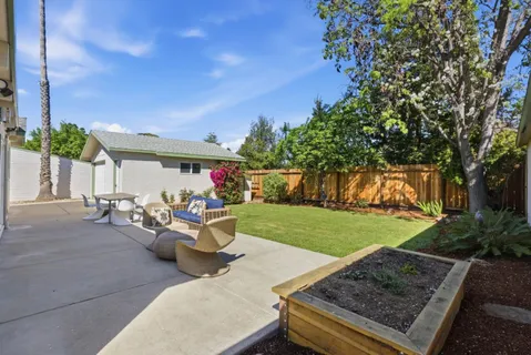 a view of a house with backyard and sitting area