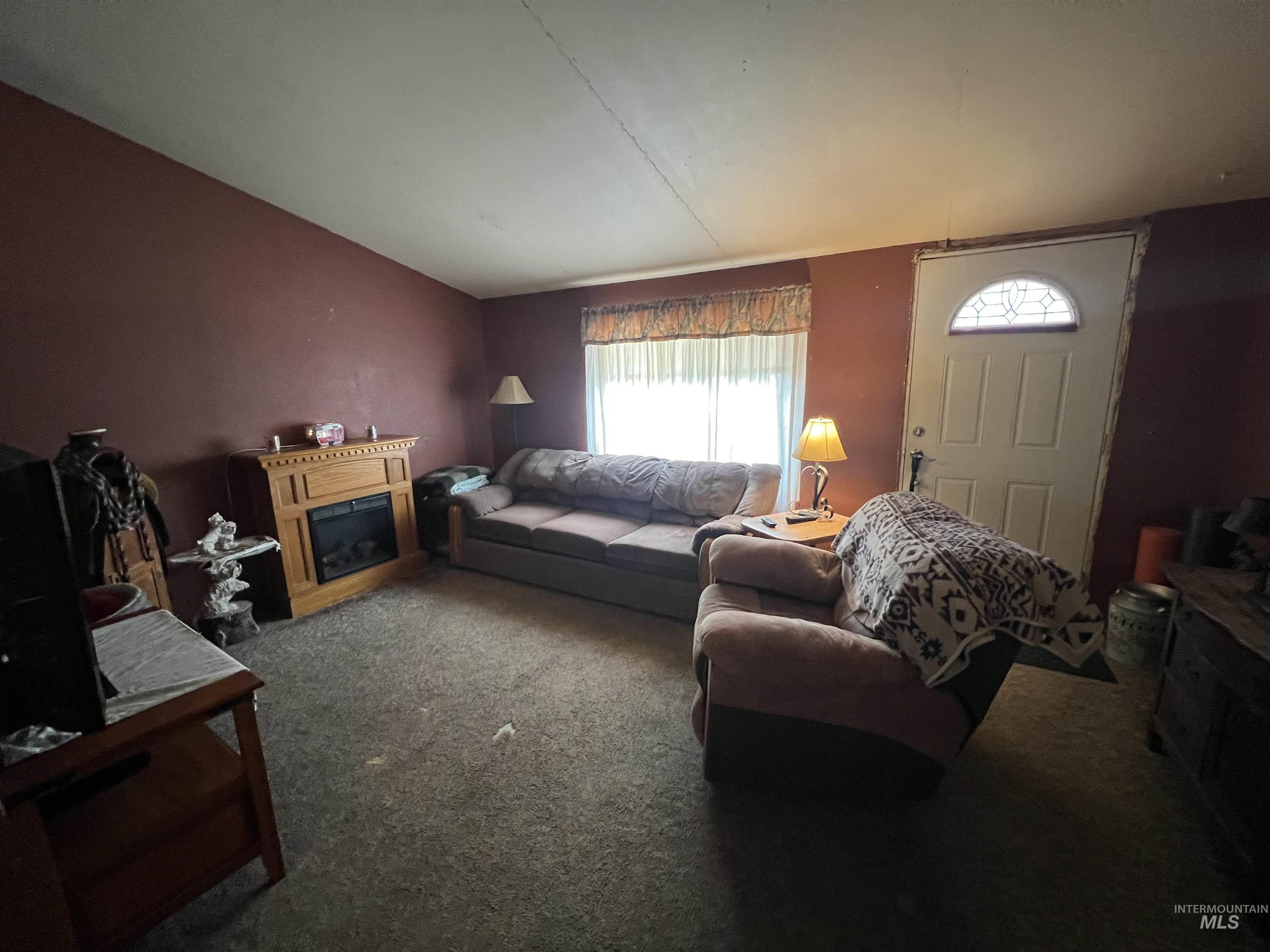 23743 Stephen Lane Parma, ID 83660 - Photo 27 of 34 Living room with carpet flooring, a fireplace, and lofted ceiling