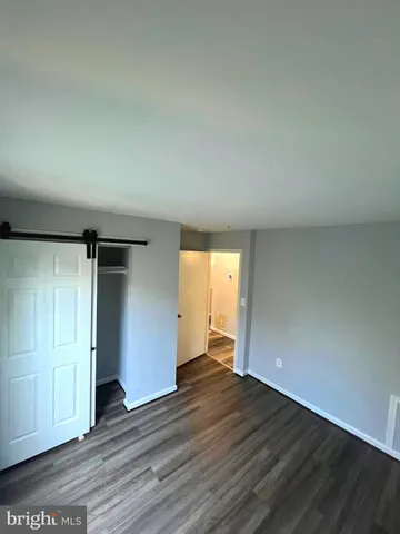 an empty room with wooden floor and closet