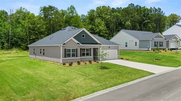 a white house with a big yard and large trees