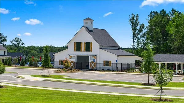 a view of a big house with swimming pool and lawn chairs under an umbrella