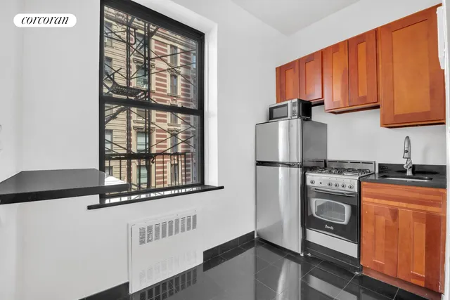 a kitchen with stainless steel appliances granite countertop a refrigerator and a stove top oven