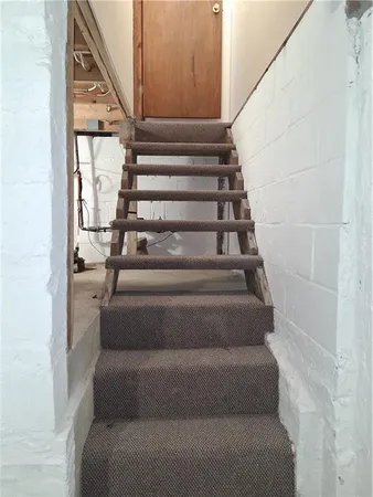a view of a room with water heater and racks on the wall