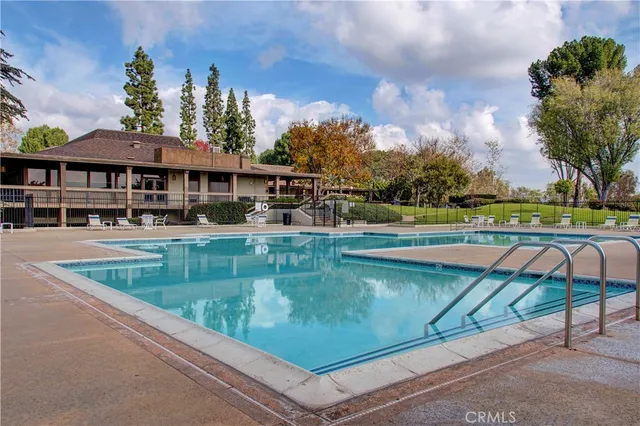 a view of a swimming pool with a garden and trees