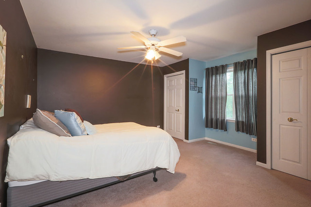 2639 Saltmeadow Road Naperville, IL 60564 - Photo 15 of 25 a bedroom with a bed and a chandelier