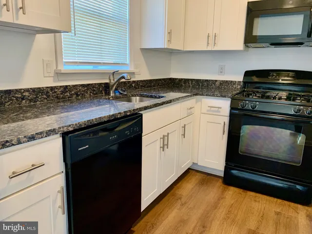 a kitchen with granite countertop cabinets stainless steel appliances and a sink