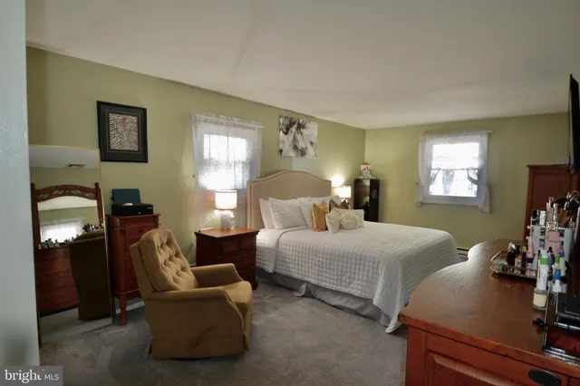 a spacious bedroom with two beds and a lamp