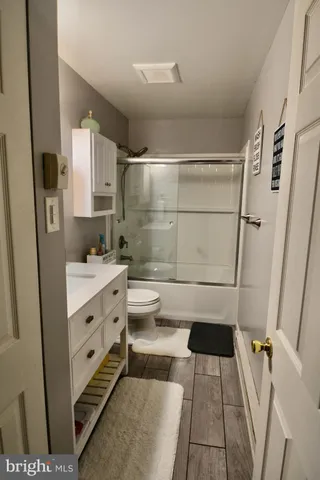 a bathroom with a sink a toilet a shower a mirror and vanity