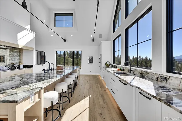 a large white kitchen with sink and a large window
