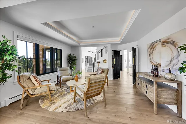 a living room with furniture a large window and wooden floor