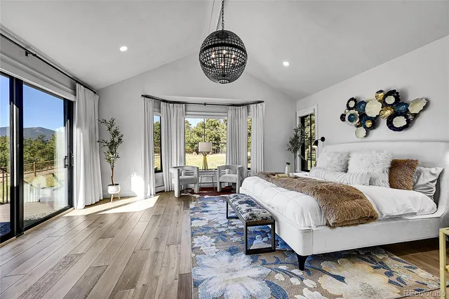 a bedroom with a large bed and a chandelier