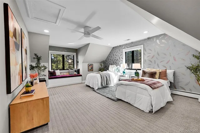 a bedroom with a bed a couch and a large window