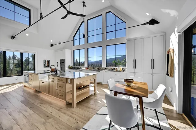 a living room with stainless steel appliances furniture large window and wooden floor
