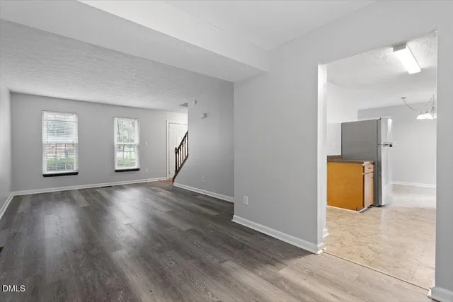 a view of empty room with wooden floor and window