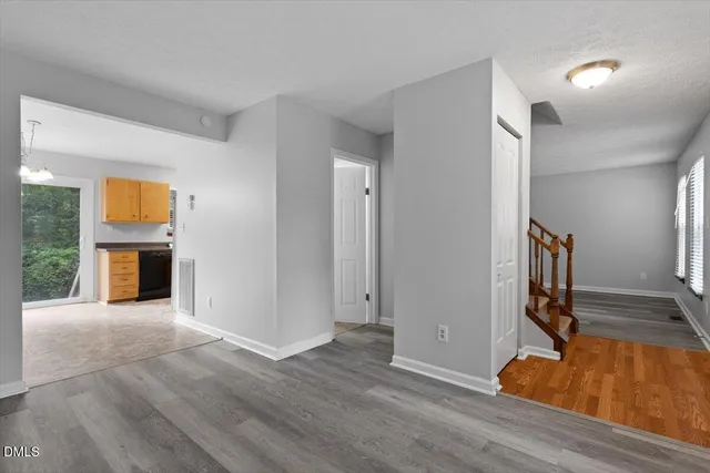 a view of an empty room with wooden floor and a fireplace