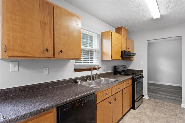 a kitchen with stainless steel appliances granite countertop a sink a stove and a microwave