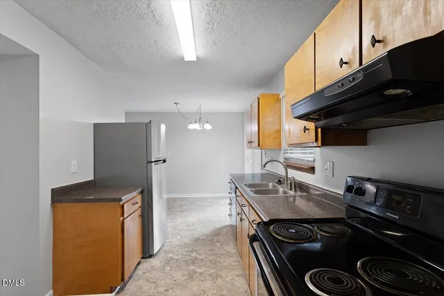 a kitchen with stainless steel appliances granite countertop a stove a sink and a refrigerator