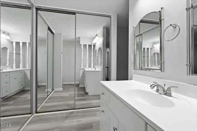 a spacious bathroom with a mirror a double vanity and a shower