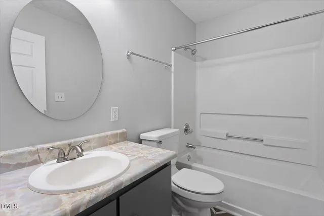 a bathroom with a granite countertop toilet sink and mirror