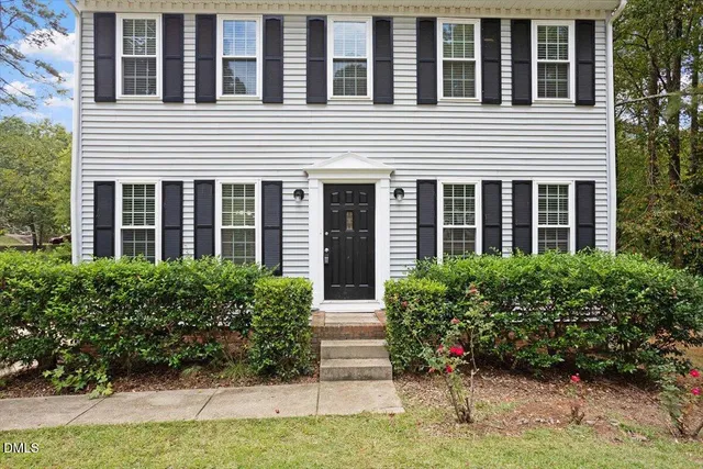 a view of a house with potted plants and a table and chair