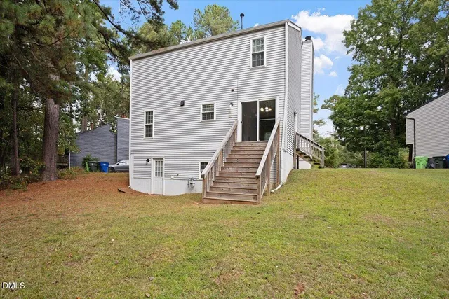 a view of a house with backyard and trees
