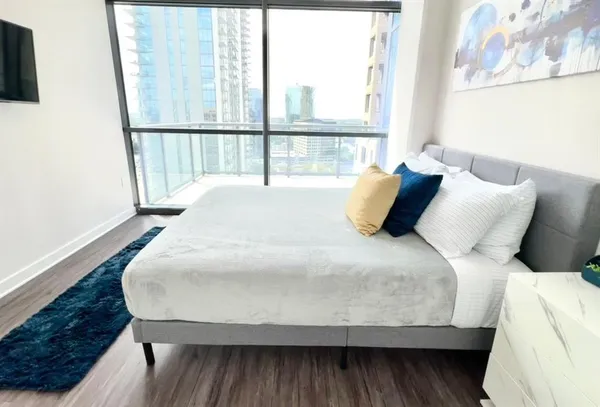 a large bed sitting in a bedroom next to a window