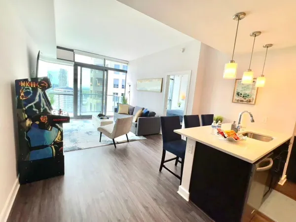 a living room with furniture a flat screen tv and a floor to ceiling window