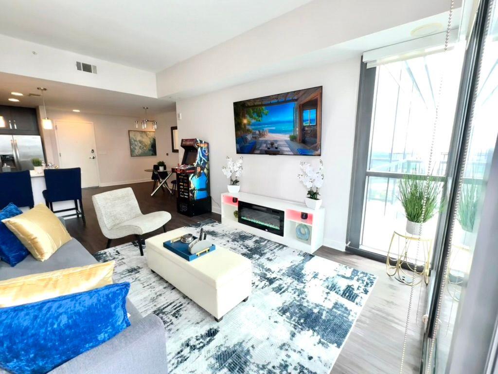 3382 Peachtree Road Northeast, Unit S08 Atlanta, GA 30326 - Photo 23 of 52 a living room with furniture a flat screen tv and a floor to ceiling window