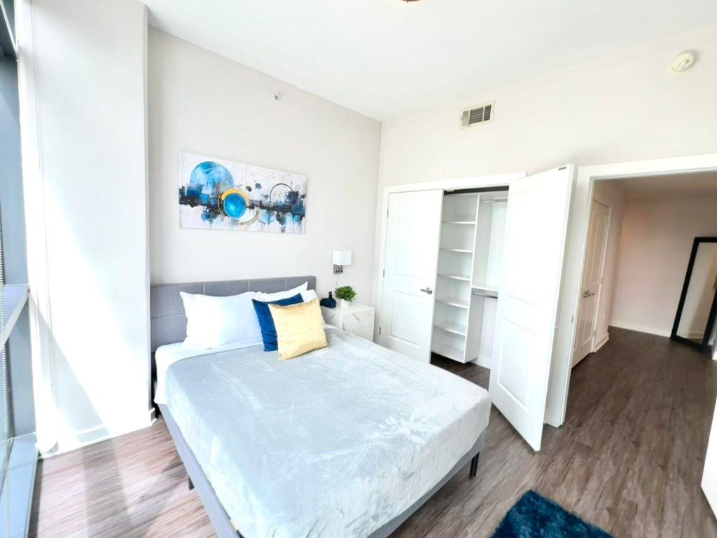 3382 Peachtree Road Northeast, Unit S08 Atlanta, GA 30326 - Photo 35 of 52 a bedroom with a bed and a wooden floor