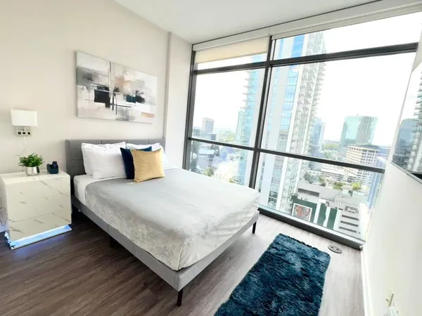 a bedroom with a bed and a large window