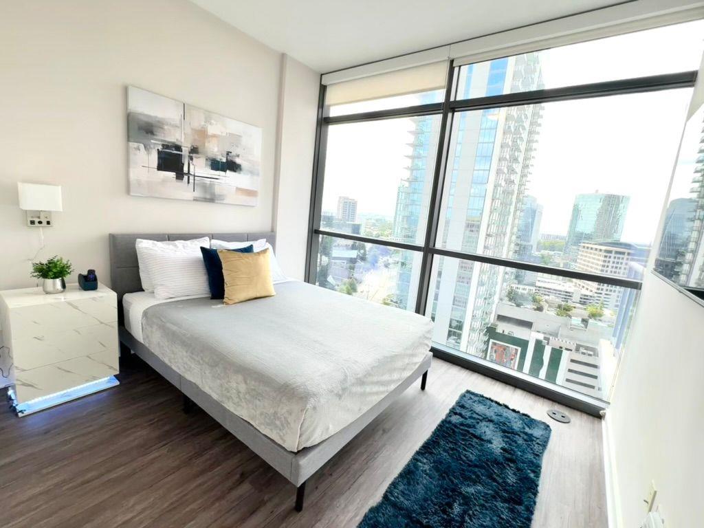 3382 Peachtree Road Northeast, Unit S08 Atlanta, GA 30326 - Photo 10 of 52 a bedroom with a bed and a large window