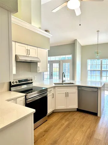 a kitchen with stainless steel appliances a sink stove and cabinets
