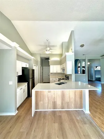 a large room with kitchen island sink and wooden floor