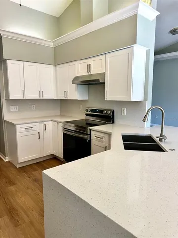 a kitchen with stainless steel appliances granite countertop a sink a stove and a refrigerator