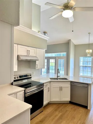 a kitchen with a sink a stove and cabinets