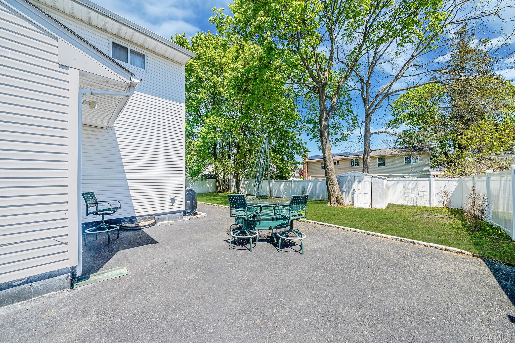 1169 Little E Neck Road West Babylon, NY 11704 - Photo 23 of 28 a view of a patio with table and chairs and a large tree
