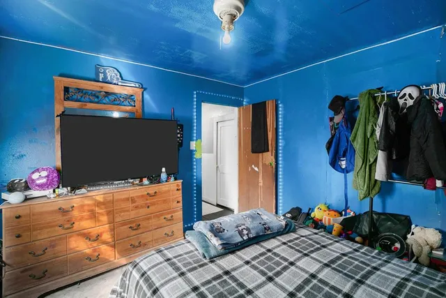 a bedroom with a bed and a flat screen tv