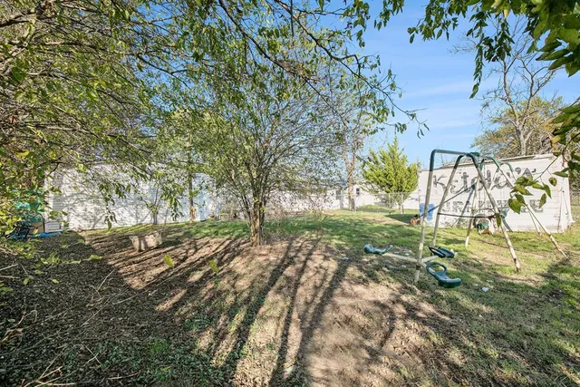 a view of a yard with a house and a large tree