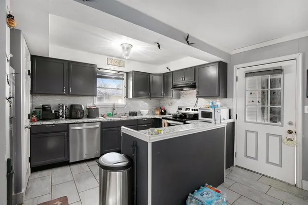 a kitchen with stainless steel appliances granite countertop a sink dishwasher stove top oven and cabinets