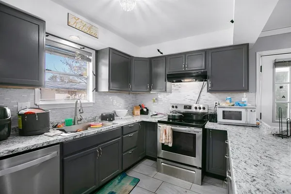 a kitchen with stainless steel appliances granite countertop a sink a stove and cabinets
