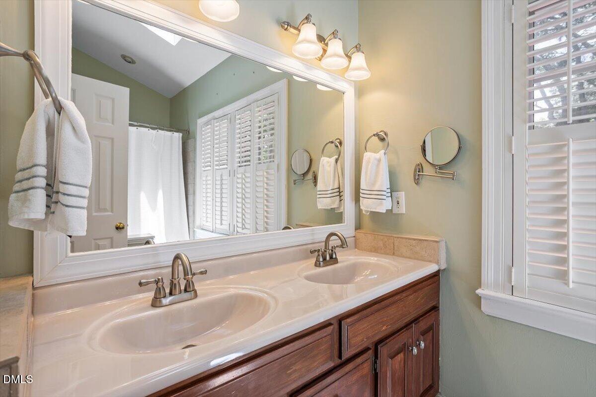 1808 Thorpshire Drive Raleigh, NC 27615 - Photo 10 of 17 a bathroom with double vanity sink a mirror and a shower