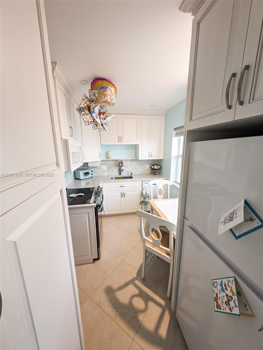 1501 South Surf Road, Unit 21 Hollywood, FL 33019 - Photo 6 of 9 a kitchen with a sink a stove and cabinets