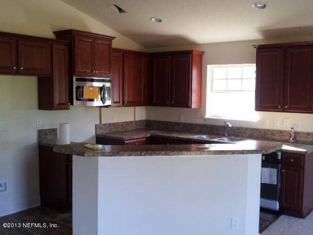 2527 Spring Pond Lane Jacksonville, FL 32221 - Photo 3 of 13 a kitchen with stainless steel appliances granite countertop a sink a stove a microwave a sink and cabinets