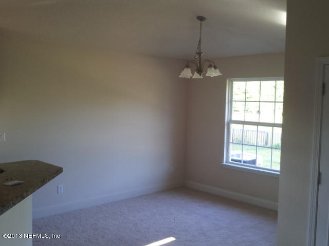 2527 Spring Pond Lane Jacksonville, FL 32221 - Photo 4 of 13 an empty room with windows and chandelier