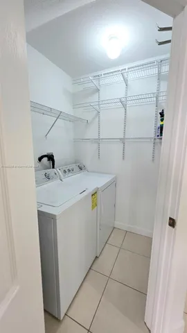 a utility room with cabinets washer and dryer