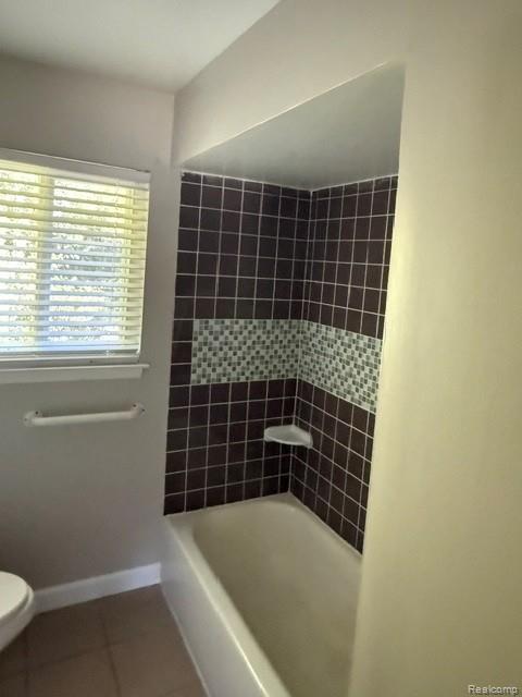 465 Trombley Road Troy, MI 48083 - Photo 12 of 24 Bathtub with dark square wall tiles and a decorative mosaic accent band